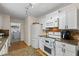 Bright kitchen featuring white appliances, granite counters, and a pass through to the laundry room at 1154 Pinebrook Rd, Auburn, GA 30011