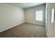 A bright bedroom with one window, a neutral carpet, and painted in a soothing light gray at 5295 Greenway Dr, Villa Rica, GA 30180