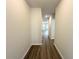 Well-lit hallway with hardwood flooring, leading to various rooms within the home at 5295 Greenway Dr, Villa Rica, GA 30180