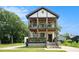 Charming two-story home showcasing a double-decker front porch with lush plants on both balconies at 1228 Ladd Sw St, Atlanta, GA 30310