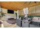 Inviting covered patio with hot tub, outdoor furniture, TV and an outdoor fan for relaxation and entertainment at 1228 Ladd Sw St, Atlanta, GA 30310