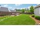 Lush backyard featuring a fire pit with stone seating, ample lawn space, and wooded fence line at 1974 Hosack Sw Hl, Marietta, GA 30064