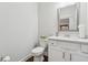 A half bathroom featuring white cabinets and a mirror at 1974 Hosack Sw Hl, Marietta, GA 30064