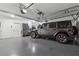 Spacious two car garage with epoxy flooring, storage cabinets, and gray Jeep Wrangler at 1974 Hosack Sw Hl, Marietta, GA 30064