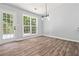 Dining area features modern lighting, a large window, and wood-look floors, and a door to the exterior at 231 Clarion Rd, Lawrenceville, GA 30043