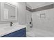 Bathroom features a single sink vanity, a tub with shower, and decorative tiling at 3216 Montheath Ct, Duluth, GA 30096