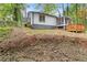 Back exterior shot of the home with lush landscaping, back deck and screened in porch at 3216 Montheath Ct, Duluth, GA 30096