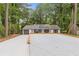 Ranch home exterior showing the driveway, white siding, new roof with solar panels, and attached garage surrounded by mature trees at 3216 Montheath Ct, Duluth, GA 30096
