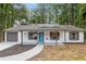 Charming single-story home boasts a new roof, solar panels, white siding, and a pop of color from the bright blue front door at 3216 Montheath Ct, Duluth, GA 30096