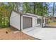 View of the home's attached garage with a freshly painted door, contrasted with the house's white siding and dark trim at 3216 Montheath Ct, Duluth, GA 30096