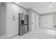Bright kitchen features stainless steel refrigerator, white cabinets and marble-patterned tile flooring at 3216 Montheath Ct, Duluth, GA 30096