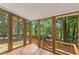 View of the screened porch with wood floors and multiple screened windows overlooking the wooded lot at 3216 Montheath Ct, Duluth, GA 30096