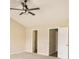 A spacious bedroom with neutral carpet, ceiling fan, and access to closets at 50 Fieldview Ln, Covington, GA 30016