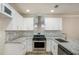 A newly remodeled kitchen featuring granite countertops, stainless steel appliances, and white cabinets at 50 Fieldview Ln, Covington, GA 30016