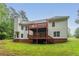 Two-story home featuring a spacious wooden deck, brick foundation, and lush green lawn at 7406 Cherry Blossom Way, Winston, GA 30187