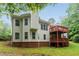 Two-story home featuring a spacious wooden deck, brick foundation, and lush green lawn at 7406 Cherry Blossom Way, Winston, GA 30187