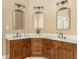 Bathroom with double sinks, wooden cabinets, and ornate mirrors at 7406 Cherry Blossom Way, Winston, GA 30187