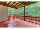 Covered deck featuring an outdoor view and red stained floor and railing at 7406 Cherry Blossom Way, Winston, GA 30187