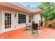 Outdoor patio with chairs, a side table, and space for entertaining with view of wooded backyard at 7406 Cherry Blossom Way, Winston, GA 30187