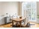 Formal dining room with large windows, elegant table and chairs, and hardwood floors at 7406 Cherry Blossom Way, Winston, GA 30187
