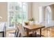 Formal dining room with large windows, elegant table and chairs, and hardwood floors at 7406 Cherry Blossom Way, Winston, GA 30187