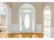 Inviting foyer with gleaming hardwood floors, white molding, and a beautiful oval-window front door at 7406 Cherry Blossom Way, Winston, GA 30187