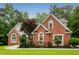 Charming red brick home featuring an immaculate lawn, arched windows, and professional landscaping at 7406 Cherry Blossom Way, Winston, GA 30187