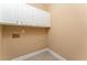 Small laundry room with tiled floor, wall cabinets, and wall outlets at 7406 Cherry Blossom Way, Winston, GA 30187