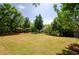 Large grassy backyard featuring lush green trees and a well-maintained lawn at 9157 Golfview Cir, Covington, GA 30014