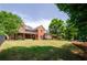 Expansive backyard featuring a brick home with a large deck and lush green lawn, perfect for outdoor activities at 9157 Golfview Cir, Covington, GA 30014