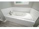 Relaxing bathroom featuring a large bathtub with jacuzzi jets and white tile surround at 9157 Golfview Cir, Covington, GA 30014