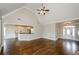 Open concept living room with hardwood floors flowing into kitchen, high ceilings, and neutral decor at 9157 Golfview Cir, Covington, GA 30014