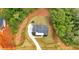 An aerial view showcases a modern home nestled on a large lot with lush landscaping and a long driveway at 157 Palisade Ne Dr, Rydal, GA 30171