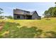 Expansive backyard featuring lush green grass and a modern gray house with ample space for outdoor activities at 157 Palisade Ne Dr, Rydal, GA 30171