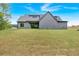 Expansive backyard featuring lush green grass, a modern gray home, and a sliding glass door to the covered patio at 157 Palisade Ne Dr, Rydal, GA 30171