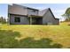 Large, grassy backyard featuring a modern gray house with a covered patio, ideal for outdoor entertaining at 157 Palisade Ne Dr, Rydal, GA 30171