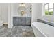 Bright bathroom featuring a stylish vanity, round mirror, tub, and elegant flooring at 157 Palisade Ne Dr, Rydal, GA 30171