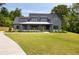 Stunning gray two-story modern farmhouse with a white porch and beautifully landscaped front yard at 157 Palisade Ne Dr, Rydal, GA 30171