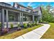 Covered front porch with stone accents, manicured landscaping, and a sidewalk at 157 Palisade Ne Dr, Rydal, GA 30171