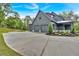 A spacious driveway leads to a modern gray home with a three-car garage and landscaped front yard at 157 Palisade Ne Dr, Rydal, GA 30171