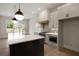 Kitchen with stainless appliances, island, stone countertops, pendant lighting, and wood accents at 157 Palisade Ne Dr, Rydal, GA 30171