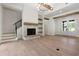 Open-concept living room with stone fireplace, hardwood floors, and modern staircase at 157 Palisade Ne Dr, Rydal, GA 30171