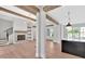 Open floor plan with view of the kitchen, living room with fireplace, and exposed wood beams at 157 Palisade Ne Dr, Rydal, GA 30171
