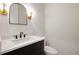 Chic powder room with elegant mirror, vanity, lighting and fixtures at 157 Palisade Ne Dr, Rydal, GA 30171