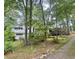 Exterior shot of a white home with back deck, a garage, and surrounded by lush green trees at 161 E 78 Hwy, Temple, GA 30179