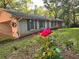 View of the side of the home with painted brick, roses, and a covered carport on a sunny day at 161 E 78 Hwy, Temple, GA 30179