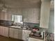 Functional kitchen with white cabinets, laminate countertops, and essential appliances at 161 E 78 Hwy, Temple, GA 30179