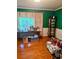 Well-lit living room with hardwood floors, green walls, and neutral-colored curtains at 161 E 78 Hwy, Temple, GA 30179