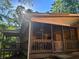 View of the screened porch, with wood railings and brick walls, providing an excellent outdoor retreat at 161 E 78 Hwy, Temple, GA 30179