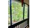 A view from the screened-in porch showing backyard trees, greenery, and natural light at 161 E 78 Hwy, Temple, GA 30179